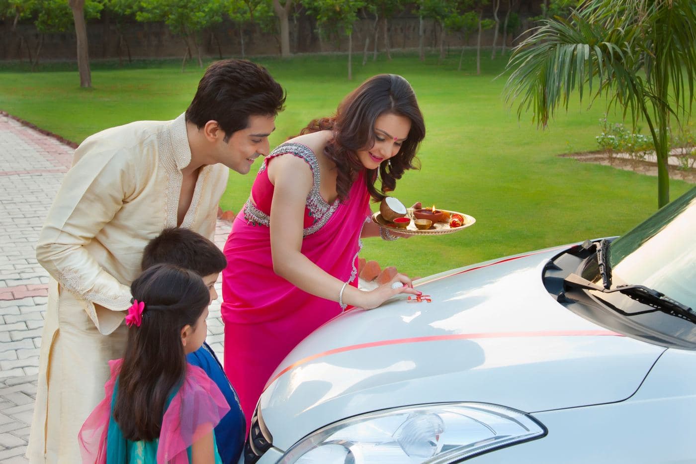A family performing a puja for their new car